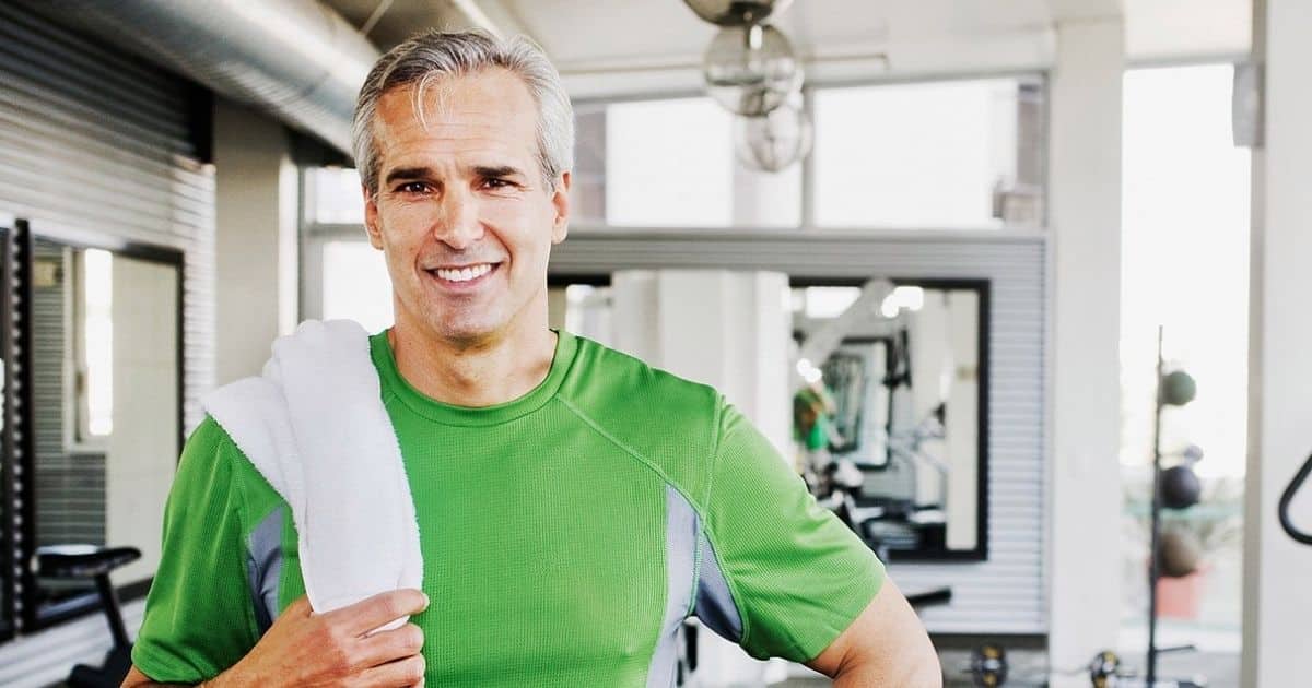 Middle aged man smiles after working out at the gym.